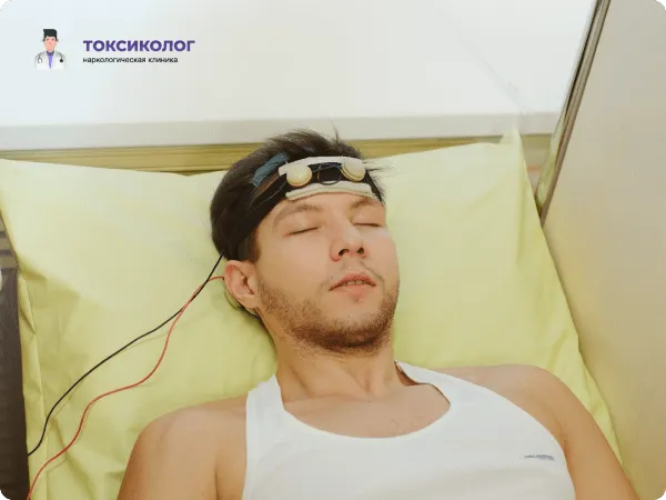 Человек лежит на кушетке во время процедуры ТЭС-терапии, направленной на снятие абстинентного синдрома